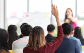 Student Raising Hand Up in a classroom
