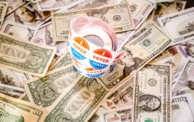 I vote Today stickers on a pile of American dollar bills politi