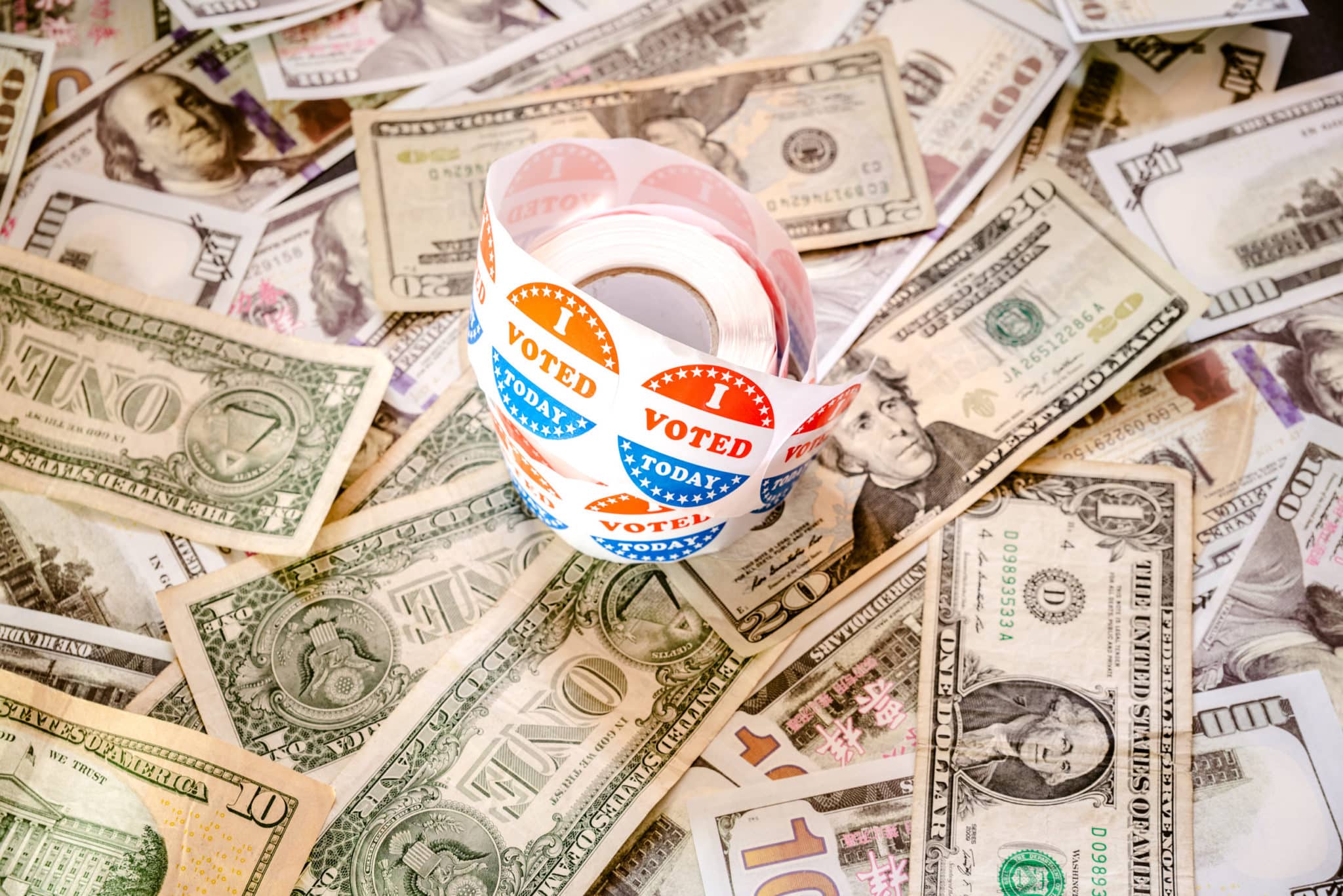 I vote Today stickers on a pile of American dollar bills politi